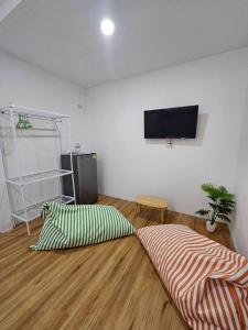 a living room with two pillows and a flat screen tv at Tiger House Hostel Koh Tao in Koh Tao