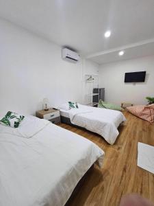 a bedroom with two beds and a flat screen tv at Tiger House Hostel Koh Tao in Koh Tao