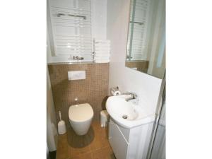ein weißes Bad mit einem Waschbecken und einem WC in der Unterkunft Holiday home Satijnduiker in Makkum