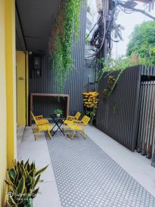 a patio with yellow chairs and tables and a fence at Shusimi Boutique Villa SG Near Tan Son Nhat Airport in Ho Chi Minh City