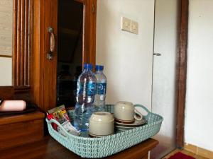 a basket with water bottles and cups on a table at Belvilla 93878 Private Room In Kintamani Near Toya Devasya in Kintamani