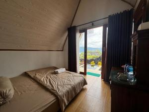a bedroom with a bed and a window with a view at Belvilla 93878 Private Room In Kintamani Near Toya Devasya in Kintamani