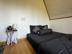 een slaapkamer met een bed en een tafel met een lamp bij Belvilla 93878 Private Room In Kintamani Near Toya Devasya in Kintamani