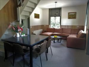 un soggiorno con tavolo e divano di Alluring Holiday Home in Erp near Forest a Erp