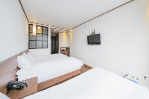 Postel nebo postele na pokoji v ubytování Tamara Jeju hotel