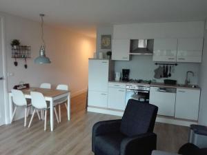 - une cuisine et une salle à manger avec une table et des chaises dans l'établissement Holiday home LEUK, à Callantsoog