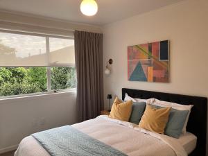 Un dormitorio con una cama grande y una ventana en Townhouse on Courtenay, en New Plymouth