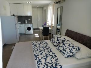 ein Schlafzimmer mit einem Bett und eine Küche mit einem Kühlschrank in der Unterkunft Studio apartman Iva in Mlini
