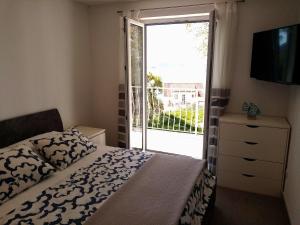 ein Schlafzimmer mit einem Bett und einer Glasschiebetür in der Unterkunft Studio apartman Iva in Mlini