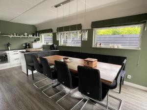 uma cozinha e sala de jantar com uma mesa de madeira e cadeiras em Holiday apartment Rietzanger for 10 peop em Makkum