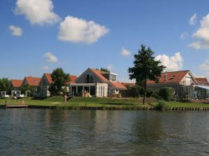 a house on the shore of a body of water at Holiday apartment Rietzanger for 10 peop in Makkum