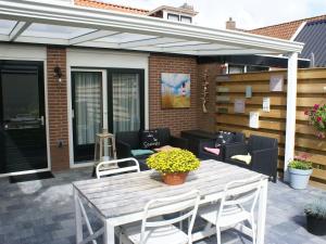 un patio con mesa de madera y sillas en Fantastic luxury vacation home and next to the Wadden Sea, en Paesens