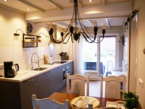 cocina con mesa de comedor y lámpara de araña en Fantastic luxury vacation home and next to the Wadden Sea, en Paesens