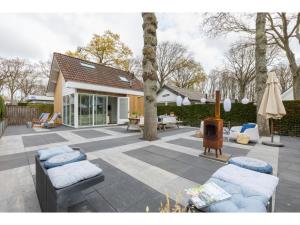 un patio con 2 sofás y chimenea en Holiday home close to the center near dunes, en Zoutelande