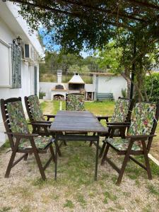 un tavolo da picnic e 4 sedie in un cortile di Mavro lithari Summer Home ad Anávissos