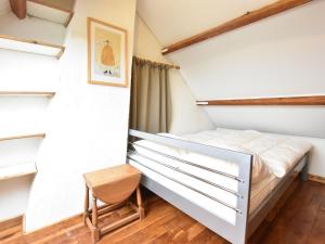 a small bedroom with a bed and a chair at Holiday Home Nieuwvliet-Bad near Beach in Nieuwvliet-Bad