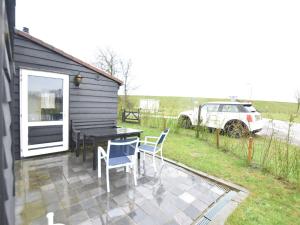 a patio with a table and chairs and a car at Holiday Home Nieuwvliet-Bad near Beach in Nieuwvliet-Bad