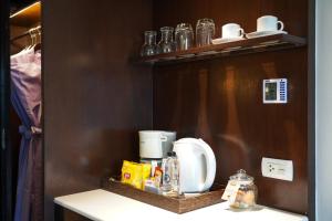 a kitchen counter with a coffee maker on a shelf at KC Grande Resort Koh Chang in Ko Chang