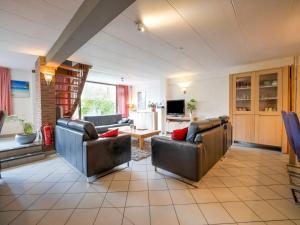 a living room with two leather couches and a tv at Serene Holiday Home in Ulestraten with Terrace in Ulestraten