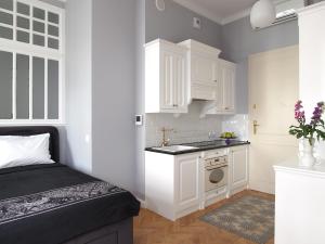 a small kitchen with white cabinets and a sink at Warsaw Concept in Warsaw +30 photos