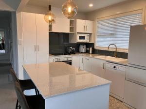 a kitchen with white cabinets and a counter top at Townhouse on Courtenay in New Plymouth