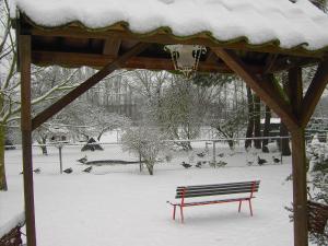 un banco sentado bajo un cenador en la nieve en Cozy Holiday Home in Bergen op Zoom with Garden, en Bergen op Zoom