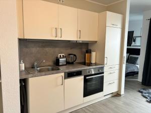 a kitchen with white cabinets and a sink at Charming Homes - Studio 23 in Wolfsburg