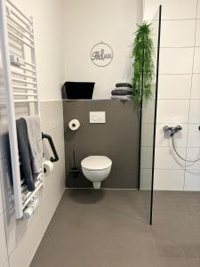 a small bathroom with a toilet and a plant at Charming Homes - Studio 23 in Wolfsburg