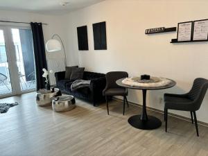ein Wohnzimmer mit einem Sofa, einem Tisch und Stühlen in der Unterkunft Charming Homes - Studio 23 in Wolfsburg