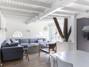 a living room with a couch and a table at Luxuriously restored farmhouse with trendy interior close to sea and forest in Groet