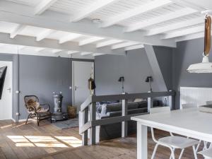 a living room with a table and a bunk bed at Luxuriously restored farmhouse with trendy interior close to sea and forest in Groet