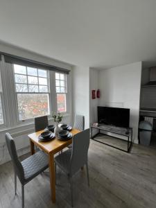 a living room with a table and chairs and a television at Tranquil 1BR in Catford in London