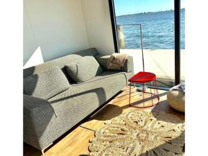sala de estar con sofá y taburete rojo en Modern houseboat in Offingawier with terrace, en Offingawier