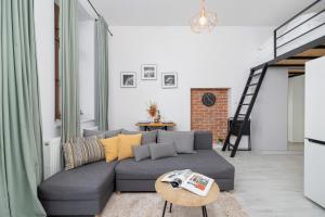 a living room with a couch and a table at Comfortable and Elegant Studio with Balcony for 4 People in Cracow by Renters in Krakow