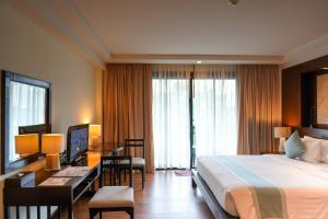 a hotel room with a bed and a desk with a computer at KC Grande Resort Koh Chang in Ko Chang