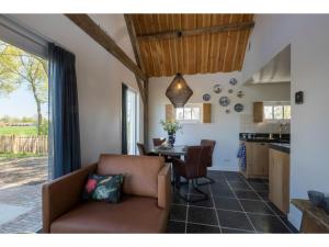 sala de estar y cocina con sofá y mesa en Family house with an ideal location private terrace garden and sauna, en Vrouwenpolder