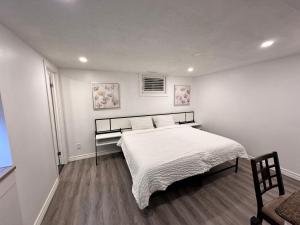 una camera da letto con un grande letto con lenzuola bianche di Riverwood Home a Mississauga