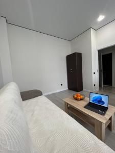 a bedroom with a bed and a laptop on a table at 1-комнатная возле Посольства США и Мечети Хазрет Султан in Astana