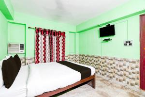1 dormitorio con 1 cama y TV de pantalla plana en OYO S.M Guest House, en kolkata