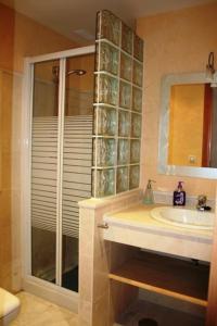een badkamer met een wastafel en een glazen douche bij Adosado en Hoyo 14, junto al campo de golf Nuevo Portil NP14442 in El Portil