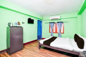 1 dormitorio con 1 cama y TV en OYO S.M Guest House, en kolkata
