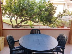 a table and chairs in a patio with a tree at Villetta Fiorita in San Vito lo Capo