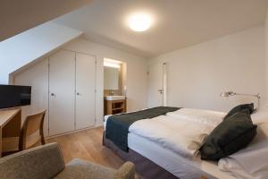 um quarto com uma cama e uma secretária com uma televisão em Gasthof Oxen em Küsnacht