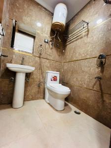 a bathroom with a toilet and a sink at Hotel Saket Place - Near Saket Metro in New Delhi