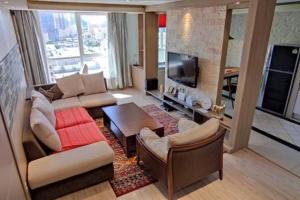 a living room with a couch and a tv at Diplomat Apartment in Ulaanbaatar
