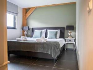 een slaapkamer met een groot bed met 2 lampen bij Modern Garden View Holiday Home in Alphen in Alphen