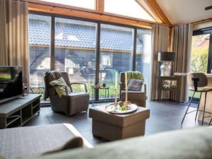 sala de estar con sofá, sillas y TV en Modern Garden View Holiday Home in Alphen, en Alphen