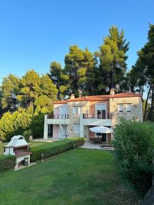 a large stone house with a yard with a yard at Pine inn Xenia in Paliouri