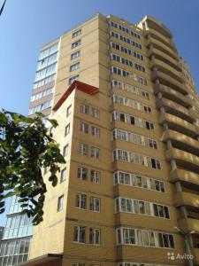 wysoki opalenizny budynek z wieloma oknami w obiekcie Apartment Sofia w Wołgogradzie