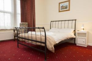 a bedroom with a bed and a chair and a window at Southend Guest House - Close to Beach, Train Station & Southend Airport in Southend-on-Sea